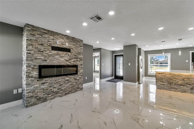 unfurnished living room featuring a fireplace and a textured ceiling