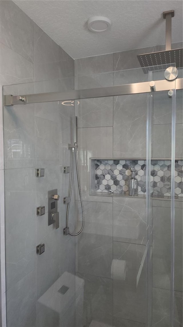 bathroom with a textured ceiling and walk in shower