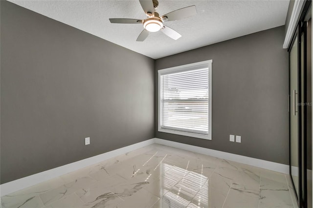 spare room featuring ceiling fan and a textured ceiling