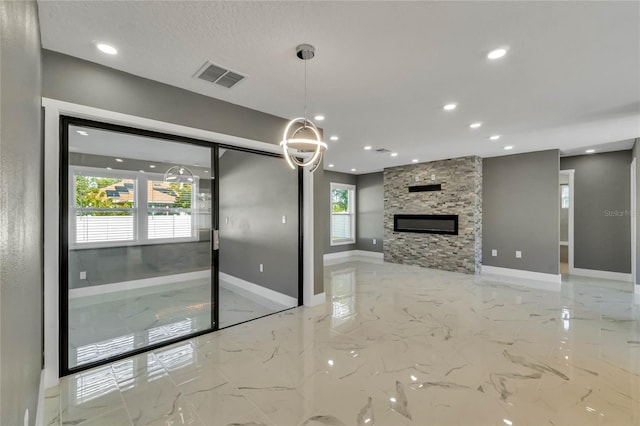 kitchen featuring decorative light fixtures, a stone fireplace, and a textured ceiling