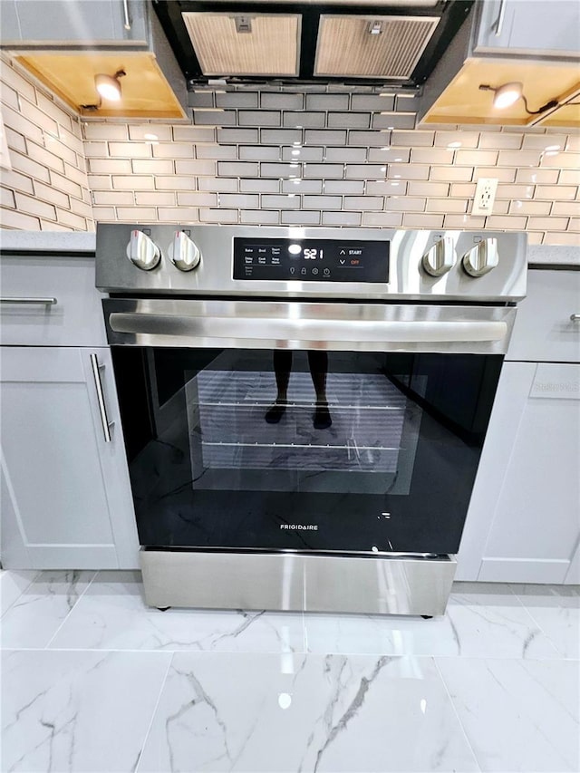 details with white cabinets, stainless steel oven, light stone countertops, and tasteful backsplash