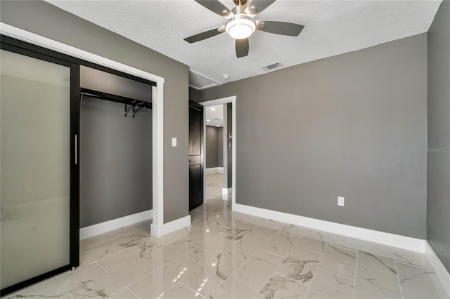 unfurnished bedroom with ceiling fan, a textured ceiling, and a closet