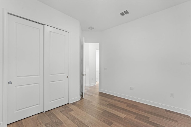 unfurnished bedroom featuring a closet and light wood-type flooring