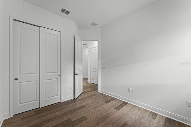 unfurnished bedroom with dark hardwood / wood-style floors and a closet