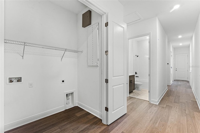 laundry area featuring electric dryer hookup, light hardwood / wood-style floors, and washer hookup