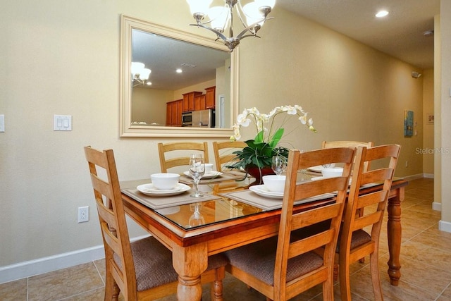 dining space with light tile patterned floors and an inviting chandelier