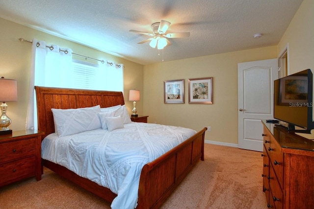 carpeted bedroom with ceiling fan and a textured ceiling