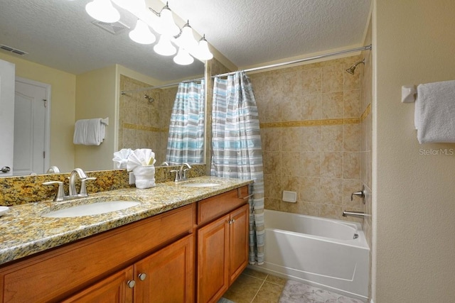 bathroom with tile patterned floors, vanity, shower / bath combination with curtain, and a textured ceiling