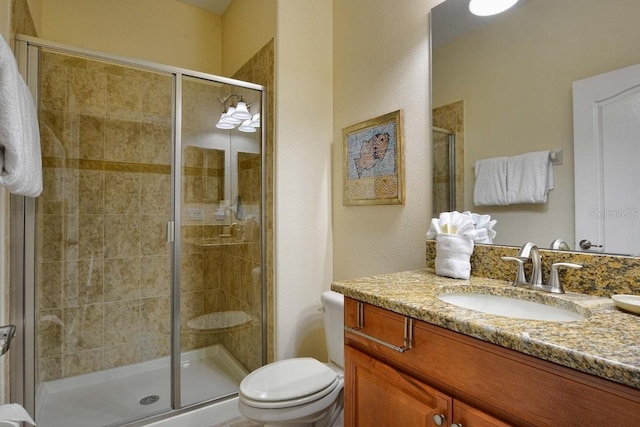 bathroom with vanity, an enclosed shower, and toilet