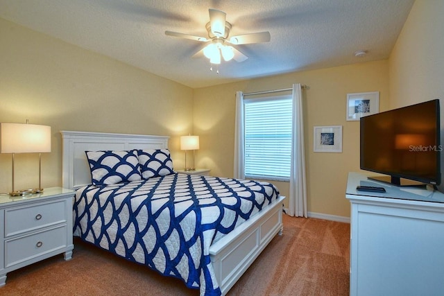 bedroom with ceiling fan, carpet floors, and a textured ceiling