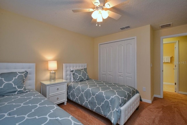 carpeted bedroom featuring ceiling fan, a textured ceiling, and a closet