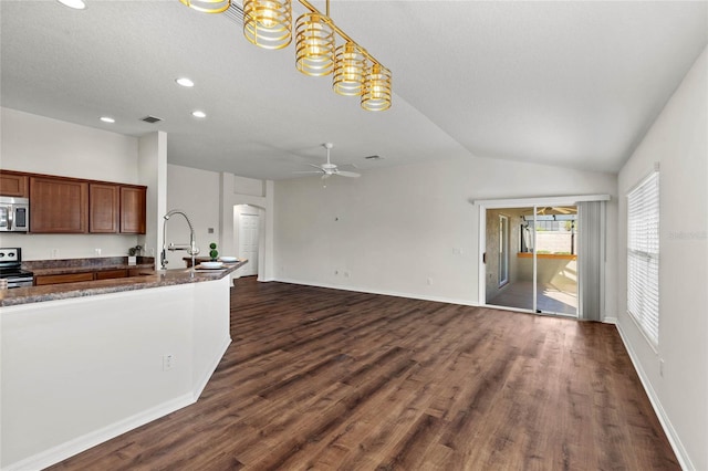 kitchen with vaulted ceiling, appliances with stainless steel finishes, dark hardwood / wood-style flooring, pendant lighting, and ceiling fan