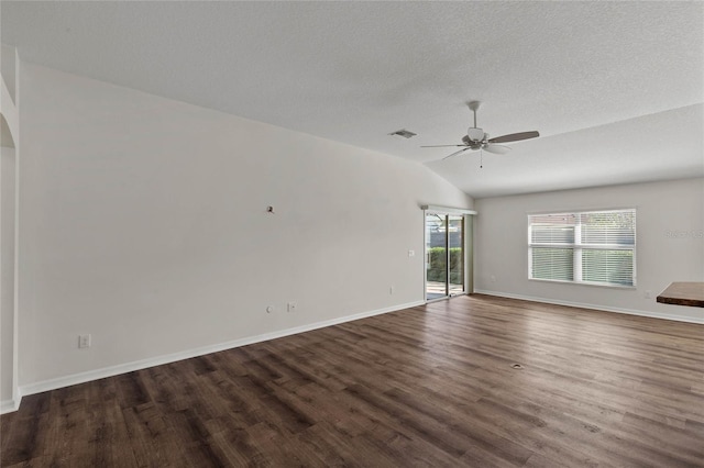 spare room with a textured ceiling, dark wood-type flooring, ceiling fan, and vaulted ceiling