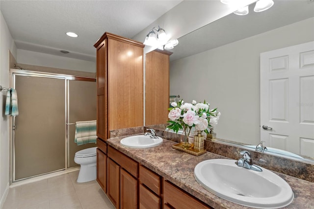 bathroom featuring vanity, toilet, an enclosed shower, and tile patterned flooring