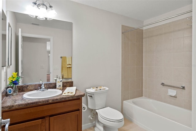 full bathroom with tile patterned flooring, tiled shower / bath, vanity, and toilet