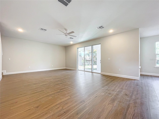 spare room with ceiling fan, plenty of natural light, and hardwood / wood-style flooring