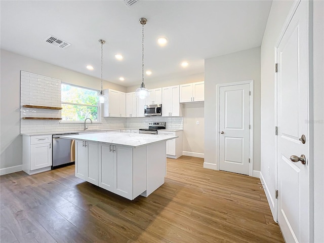 kitchen with a center island, sink, white cabinets, and appliances with stainless steel finishes