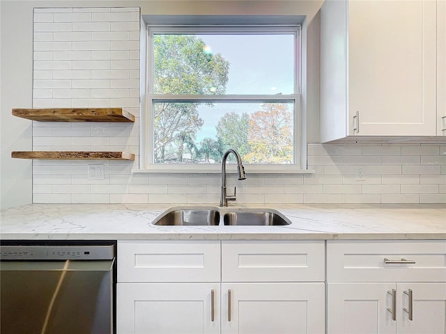 kitchen featuring dishwasher, white cabinets, sink, light stone countertops, and tasteful backsplash