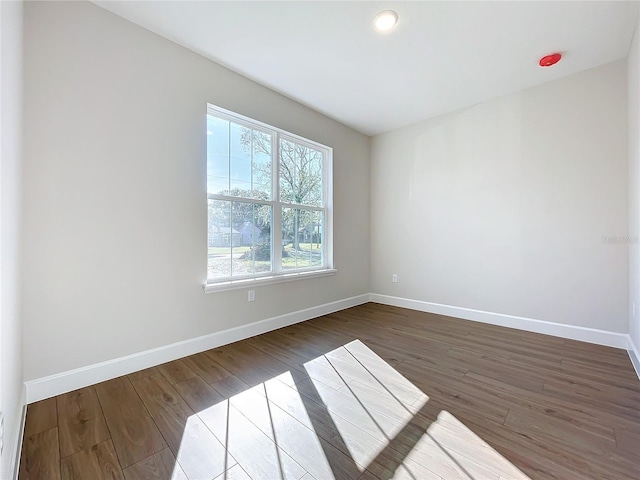 empty room with dark hardwood / wood-style flooring