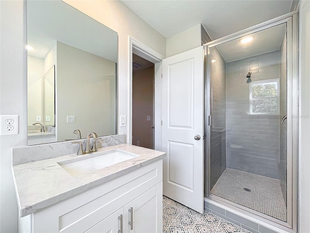 bathroom with vanity and a shower with shower door