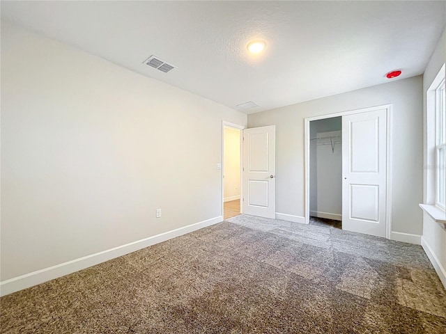 unfurnished bedroom with carpet flooring and a closet