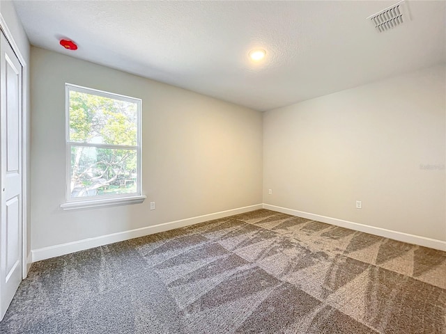 spare room with carpet flooring and a textured ceiling