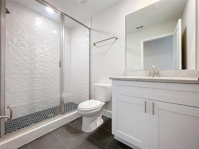 bathroom featuring tile patterned floors, vanity, toilet, and a shower with shower door