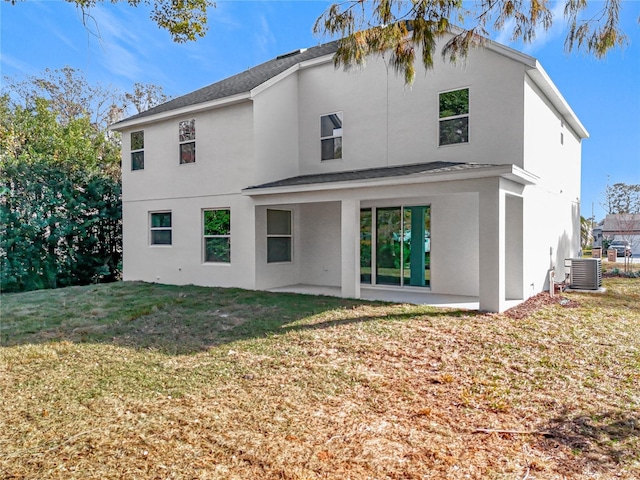 rear view of property with a patio, central AC unit, and a lawn