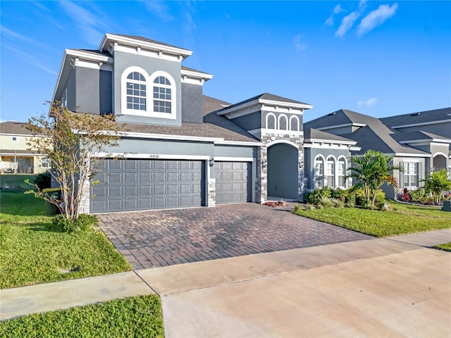 4408 Renly Ln, Clermont, FL 34711 - view of front of home with driveway, stucco siding, a front lawn, and stone siding