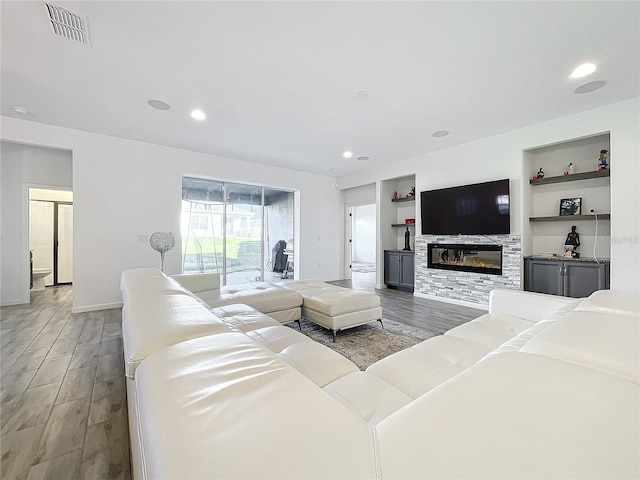 4408 Renly Ln, Clermont, FL 34711 - living room featuring light wood-type flooring, built in features, a stone fireplace, and recessed lighting