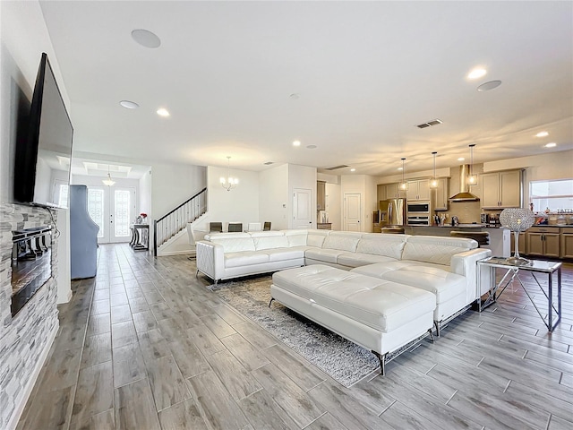 living room with light hardwood / wood-style floors, an inviting chandelier, and french doors