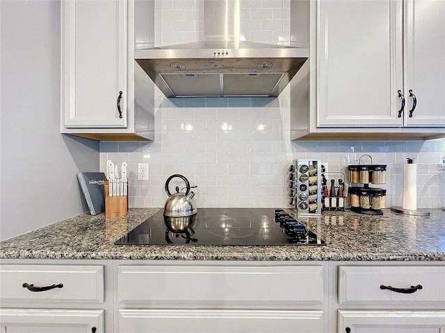4408 Renly Ln, Clermont, FL 34711 - kitchen with wall chimney exhaust hood, black electric stovetop, decorative backsplash, white cabinetry, and dark stone counters