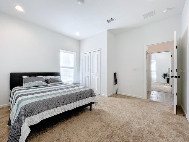 bedroom featuring light carpet and a closet