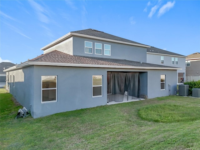 rear view of house with a yard and cooling unit