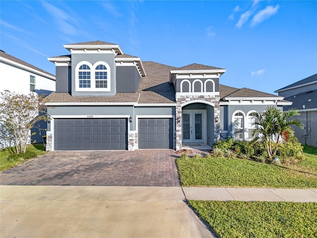 4408 Renly Ln, Clermont, FL 34711 - view of front of property featuring french doors, decorative driveway, stucco siding, and stone siding