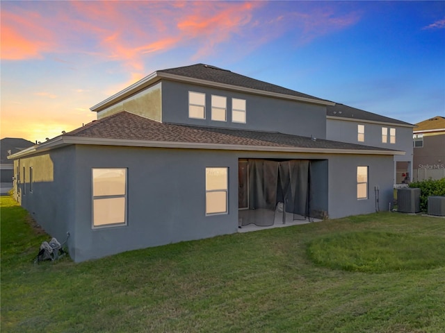 4408 Renly Ln, Clermont, FL 34711 - back of house at dusk with a yard, stucco siding, and roof with shingles