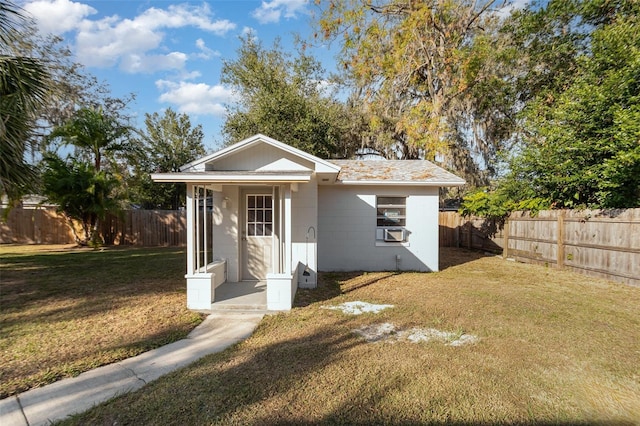 exterior space featuring cooling unit and a front lawn