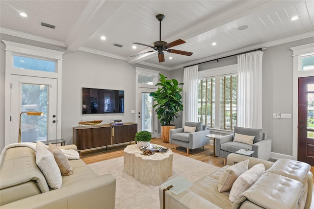 living room featuring plenty of natural light, ornamental molding, and light wood-type flooring