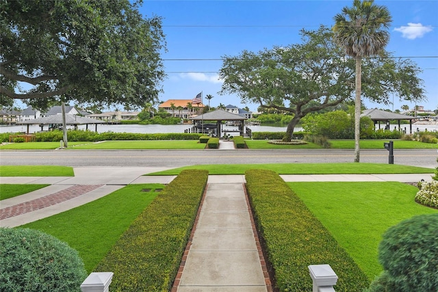 view of home's community with a gazebo, a water view, and a lawn