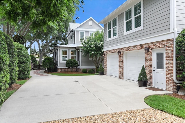 view of front of property featuring driveway, brick siding, and an attached garage