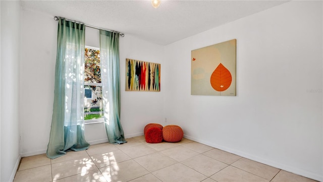 empty room with light tile patterned flooring and a healthy amount of sunlight