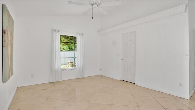 spare room featuring ceiling fan, light tile patterned flooring, and lofted ceiling