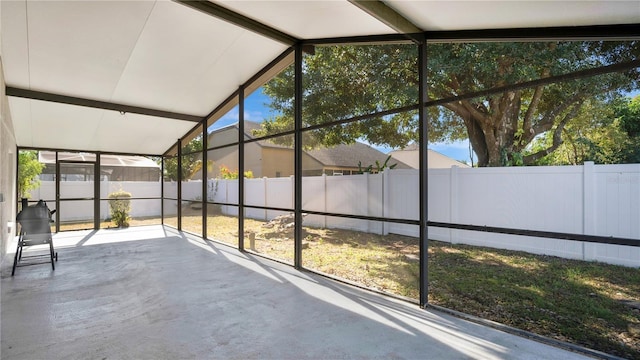 unfurnished sunroom with a healthy amount of sunlight and vaulted ceiling with beams