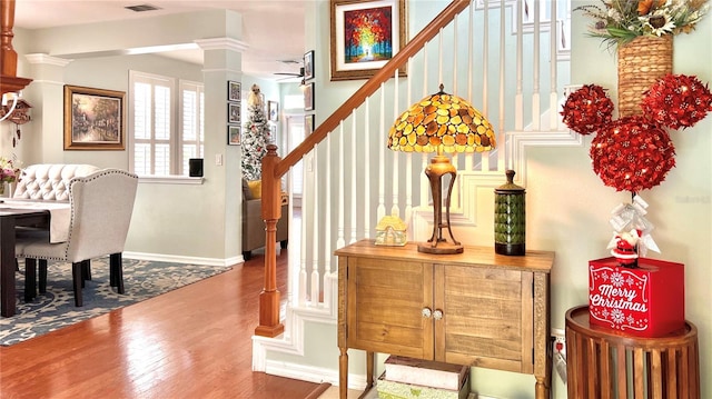 foyer entrance with hardwood / wood-style flooring and ornate columns