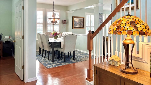 dining space featuring wood-type flooring and a notable chandelier