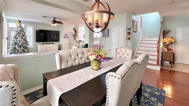 dining area with hardwood / wood-style flooring and ceiling fan with notable chandelier