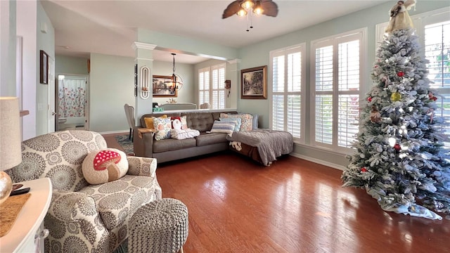 living room with ceiling fan with notable chandelier, a healthy amount of sunlight, and dark hardwood / wood-style floors