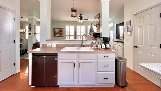 kitchen featuring pendant lighting, white cabinets, stainless steel dishwasher, and sink