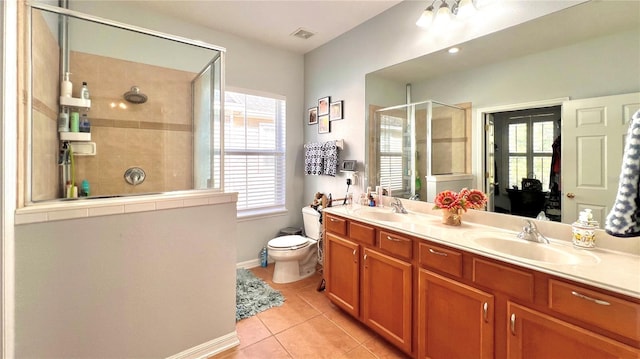 bathroom with tile patterned floors, vanity, a shower with shower door, and toilet