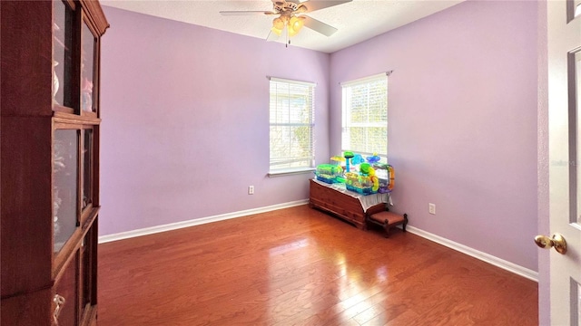 spare room featuring ceiling fan and dark wood-type flooring